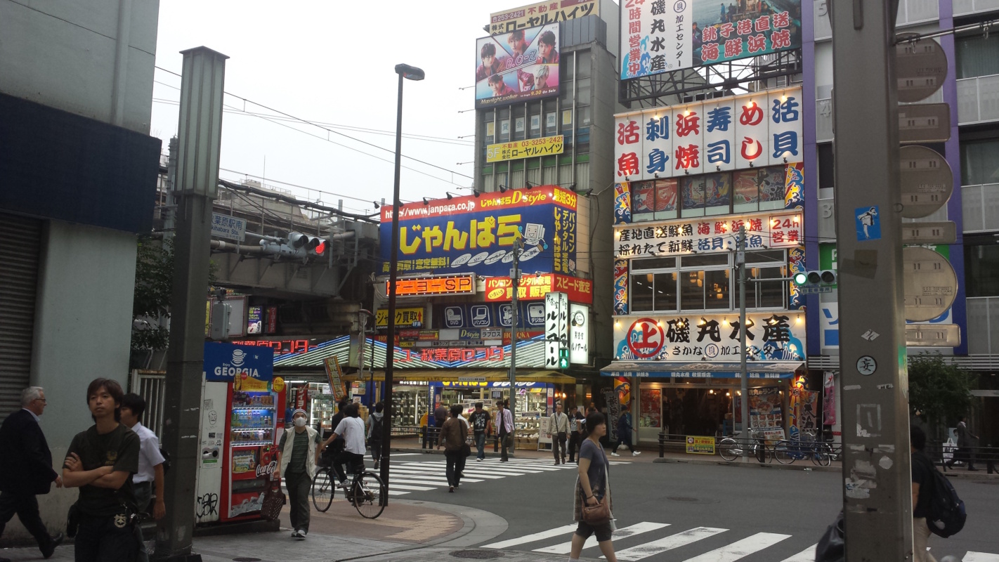 Photo of a street crossing in Japan with large store signs on the other side