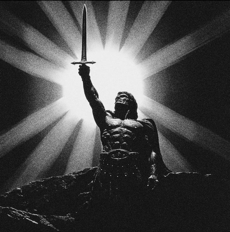 Black-and-white image of a muscular warrior holding up a sword