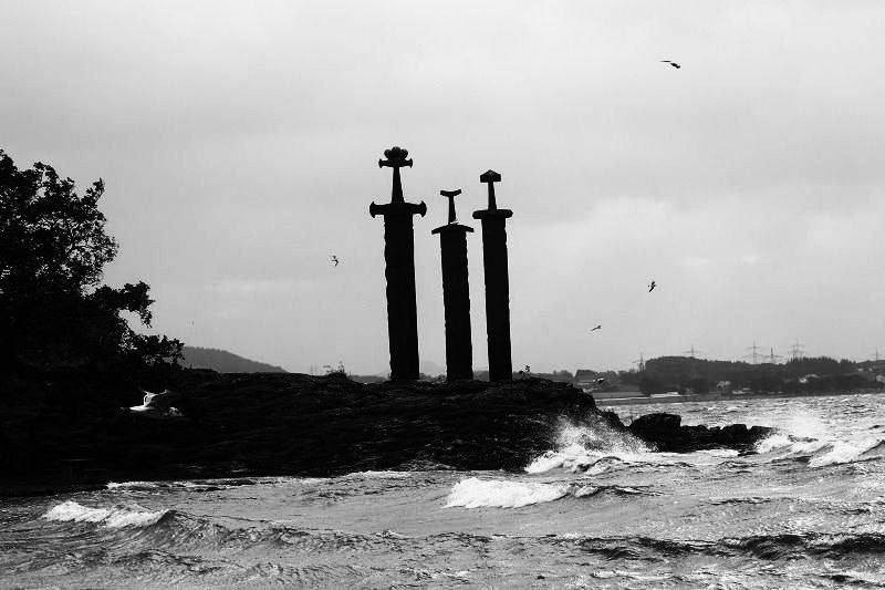 Heavily filtered photo of a monument of three giant swords