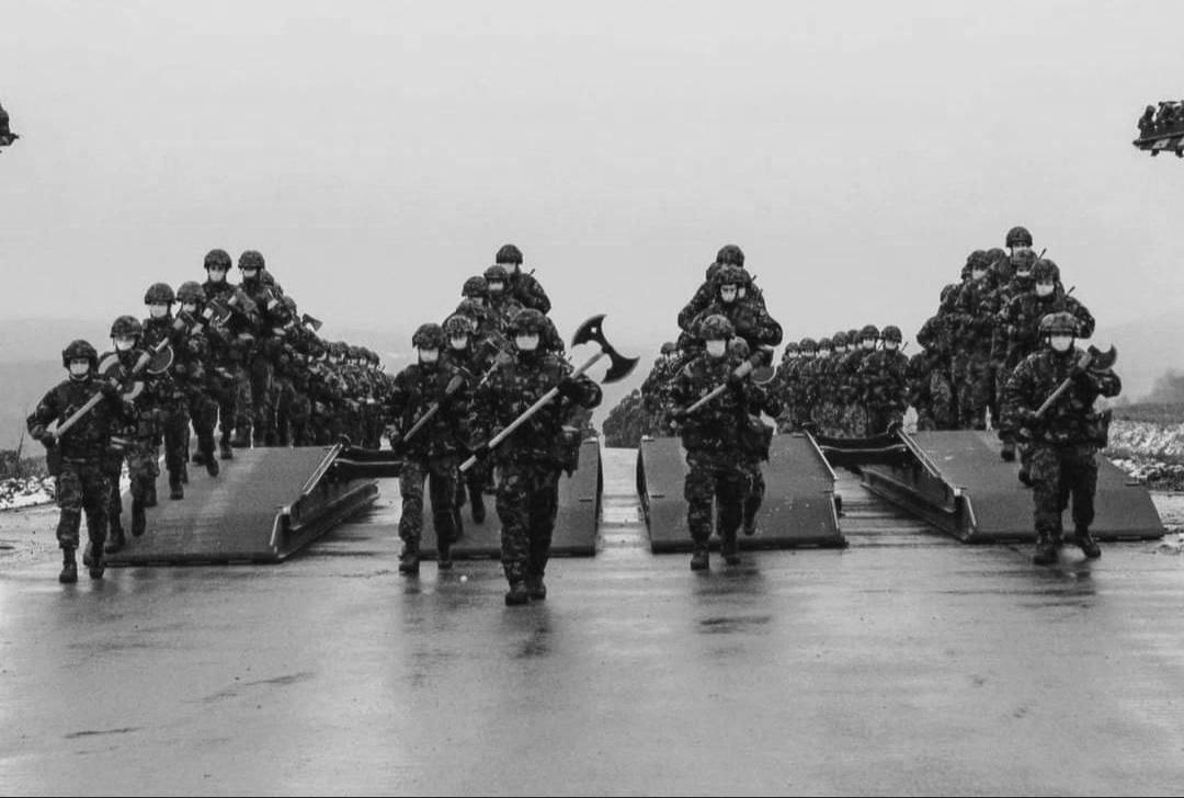 Black-and-white photo of soldiers armed with axes