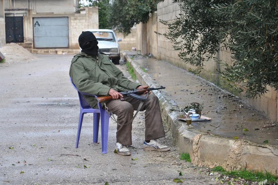 Photo of an FSA fighter guarding the streets on a plastic chair