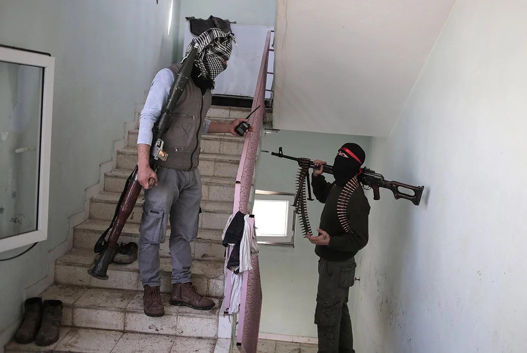 Photo of two armed members of the YDG-H having a talk on a staricase